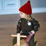 girl wearing red hat and knitted and embroidered holiday goose cardigan in dark green shade