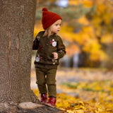 girl wearing ribbed leggings and knitted and embroidered holiday goose cardigan in dark green shade