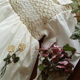 Close-up of a textured white fabric with floral embroidery on a wooden surface