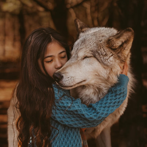 a girl wearing smock knitted turtleneck in petroleum shade and hugging a dog