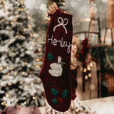 Person holding a personalized Christmas stocking with a festive background