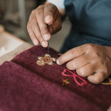 Close-up of dark grape holiday stocking, highlighting intricate details and punch needle craftsmanship.