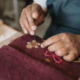 Close-up of dark grape holiday stocking, highlighting intricate details and punch needle craftsmanship.