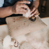 Crafting process of a pink hand-felted ballerina ornament, highlighting the intricate wool felting techniques and artisan's skill in creating this elegant decoration.