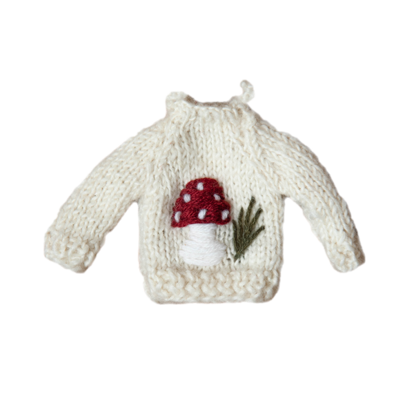 Knitted Sweater Ornament featuring an embroidered mushroom motif, displayed in a festive setting, showcasing its charming design and detail.