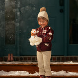 little girl in a snow wearing hellebores cardigan