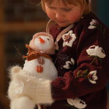 little girl holding a snowman in hellebores cardigan