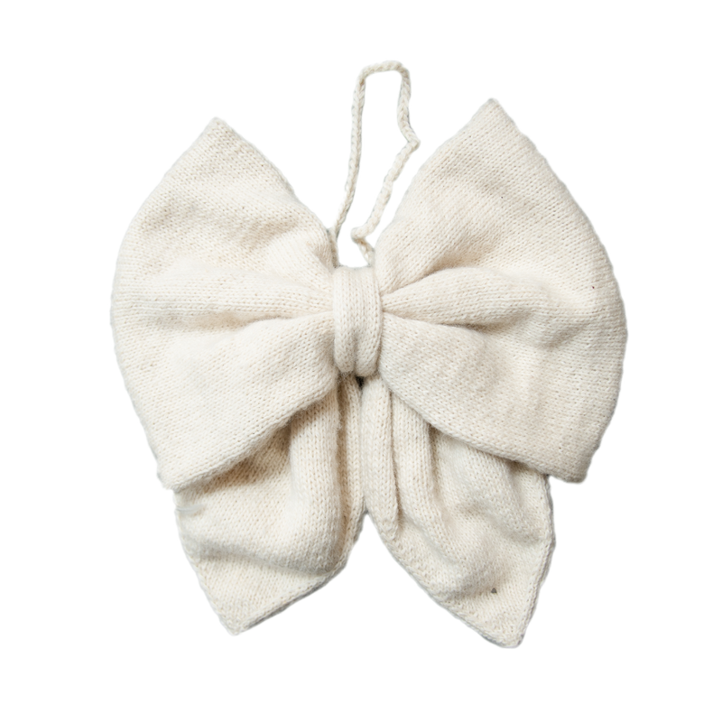 Hand-knitted cream Christmas bow made from 100% sheep wool, showcasing its large size and intricate craftsmanship.