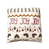 Joy Pillow Cover in Cream White, hand-knitted from 100% merino wool with a wooden button closure, featuring intricate hand-embroidered details and festive JOY design.