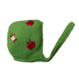 A green wool bonnet with hand-embroidered red apples.
