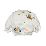 White sweater with floral embroidery on a white background