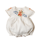 White baby romper with floral embroidery on a white background