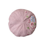 Pink knit beret with floral embroidery on a white background