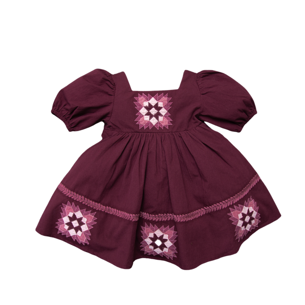 A short-sleeved patchwork dress in purple with floral embroidery, presented against a plain background.