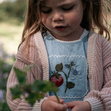 Young girl holding a plant in an outdoor setting