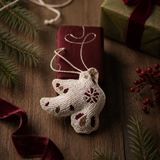 beaded dove christmas ornament laying on wooden table on a gift