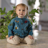 little girl in knitted and embroidered bugs life cardigan