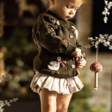 little girl in a christmas outfit featuring our knitted and embroidered holiday goose cardigan in pine color