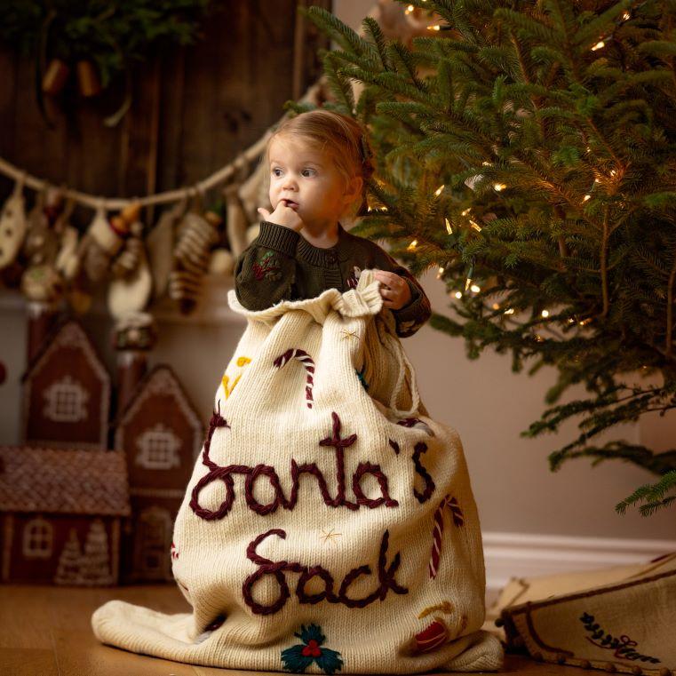 little girl in a big santa sack with hand embroidery