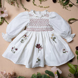 white sewn dress for kids with smock details and flower embroidery