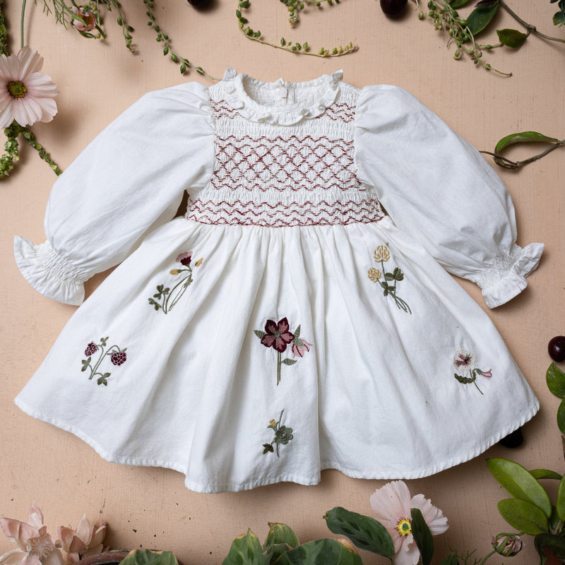 white sewn dress for kids with smock details and flower embroidery