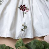 close up of white dress for kids with flower embroidery