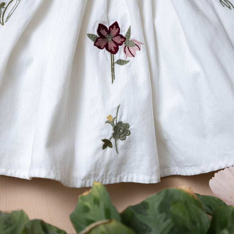 close up of white dress for kids with flower embroidery