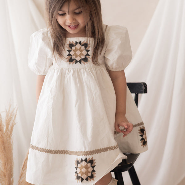 girl in white patchwork dress