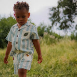 Child wearing the Ladybird Set, surrounded by greenery and nature.







