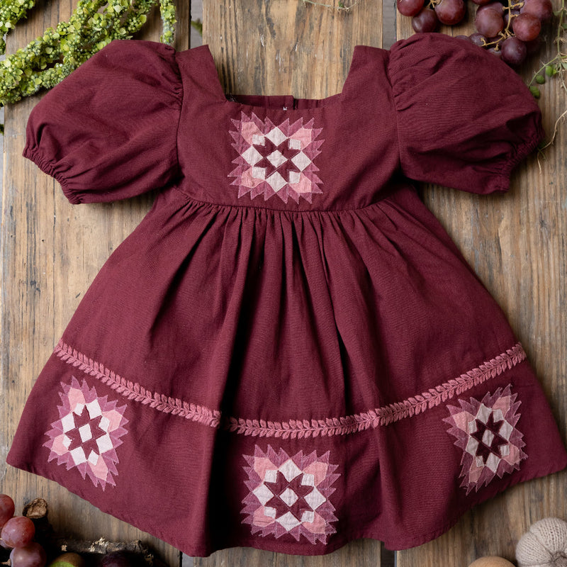 grape patchwork dress on a wooden background