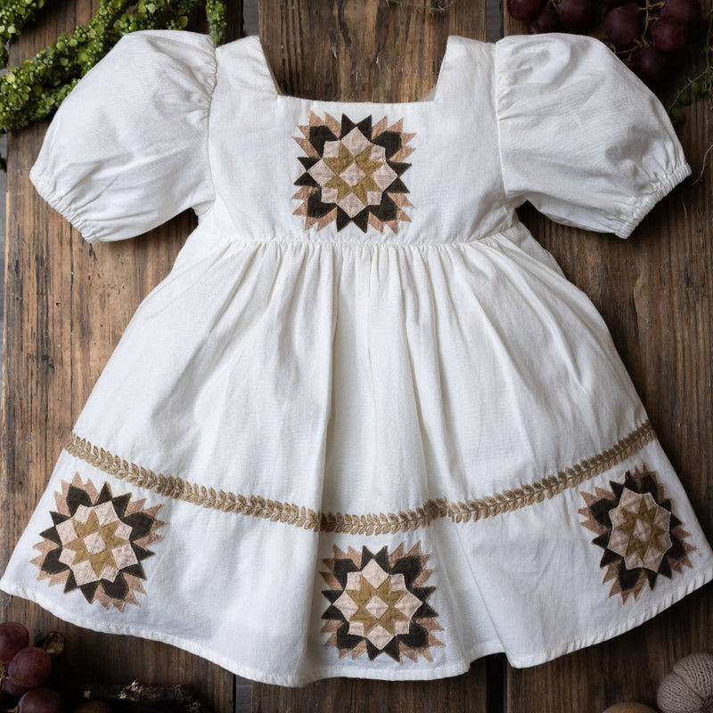 white patchwork dress on a wooden background