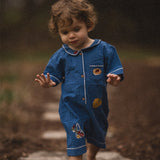 Child in blue outfit walking on a path in a natural setting