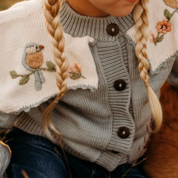 Part of the Little Birdie cardigan showing the embroidered details, with no child visible.







