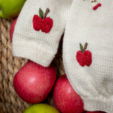 close up of knitted and embroidered apple romper for babiees