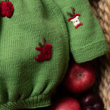 close up of a knitted apple romper for babies