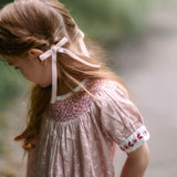 Young girl in a floral dress with a blurred natural background