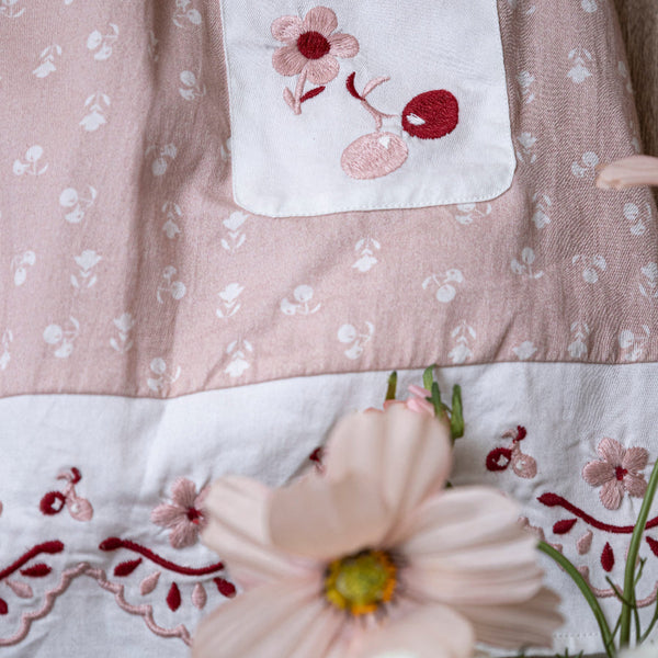 close up of pink sewn dress for kids with handcrafted details