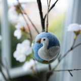 Decorative goose ornament on a branch with flowers