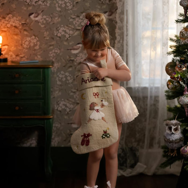 little girl holding the felted personalized odette stocking for christmas