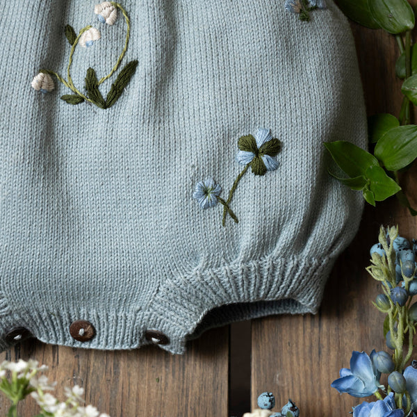 blue knitted and hand embroidered botanical romper