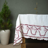 white tablecloth for holidays with printed red bows on edges