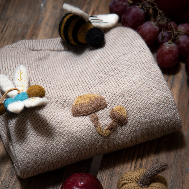 close up of the knitted and embroidered bugs life cardigan for children