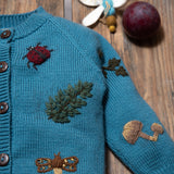 close up of petroleum knitted and embroidered bugs life cardigan