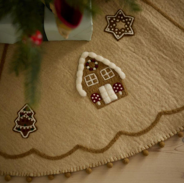 Close-up of gingerbread houses on Gingerbread House Heirloom Tree Rug, highlighting intricate handcrafted details and festive decorations.