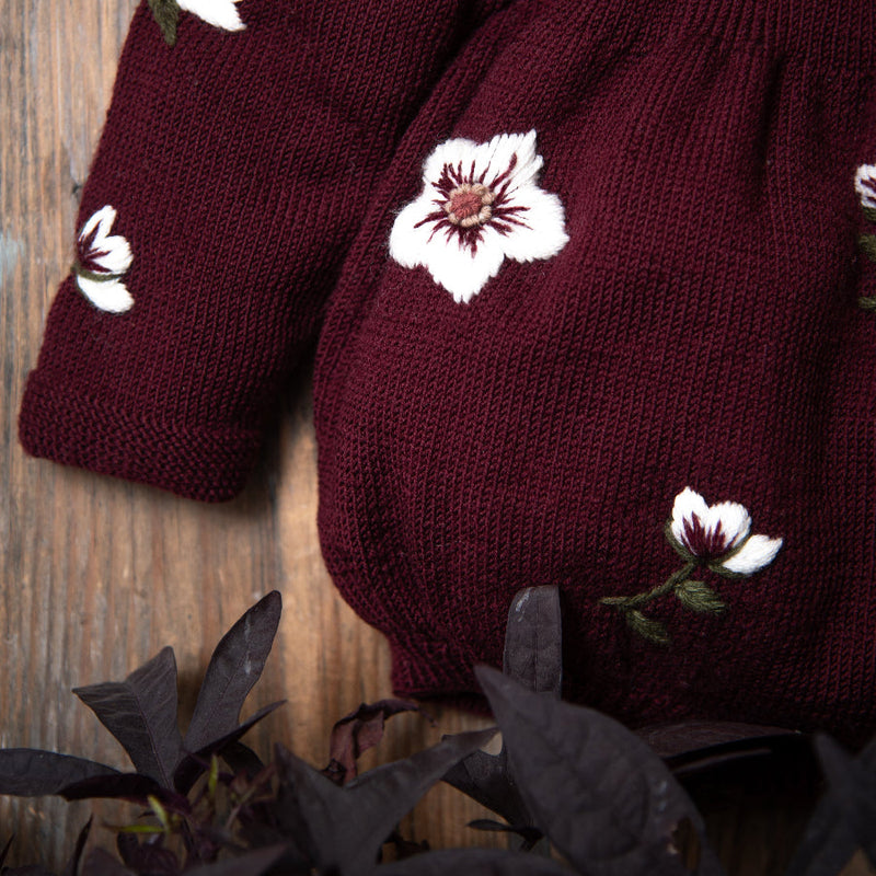 close up of the hellebores romper grape with embroidered flowers