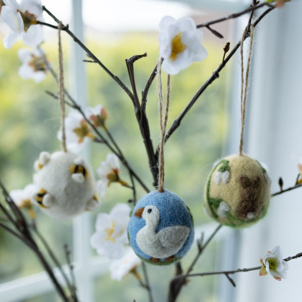 Artisan Easter Egg Ornament Bunny Butt – Yellow hanging from a decorative tree, alongside several similar handcrafted woolen Easter egg ornaments, creating a festive Easter display.

