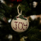 Bauble Ornament Joy in Cream White hanging on a Christmas tree, adding a touch of elegance and handmade charm to festive decorations.