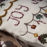 Close-up of hand-knitted Joy Pillow Cover in Cream White, made from 100% merino wool, showcasing detailed hand embroidery and wooden button closure.