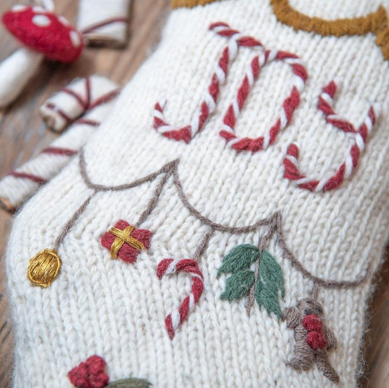 Close-up of 'Joy' embroidery on Christmas stocking, highlighting intricate hand-embroidered details and festive design.