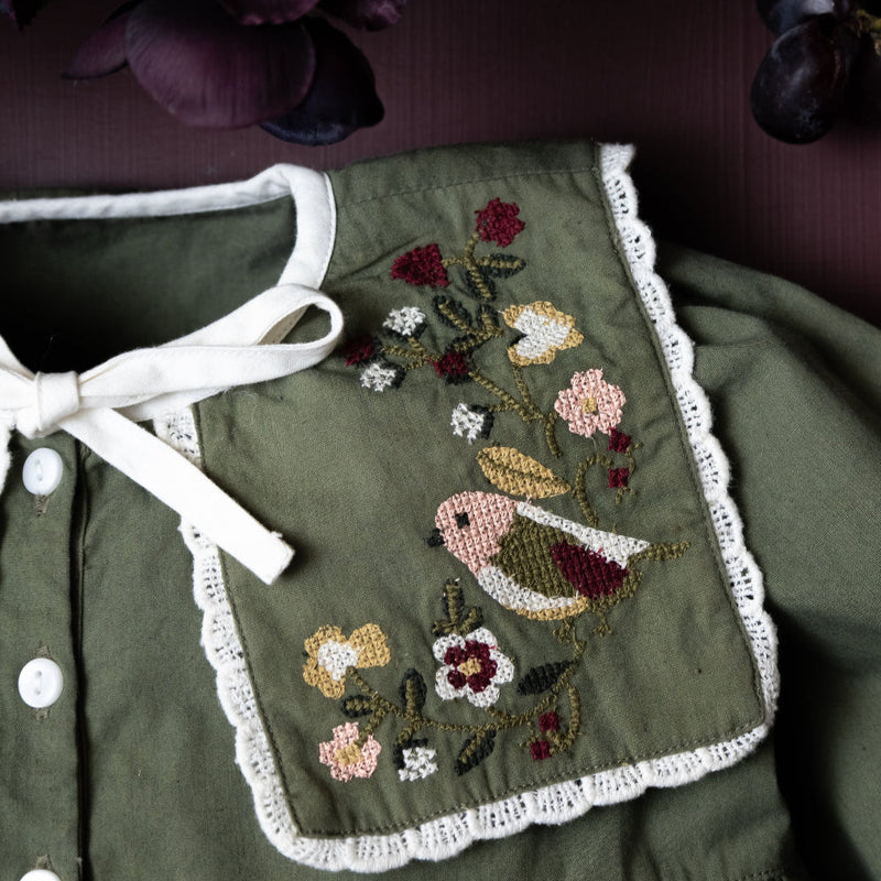 close up of embroidered collar with flowers and bird